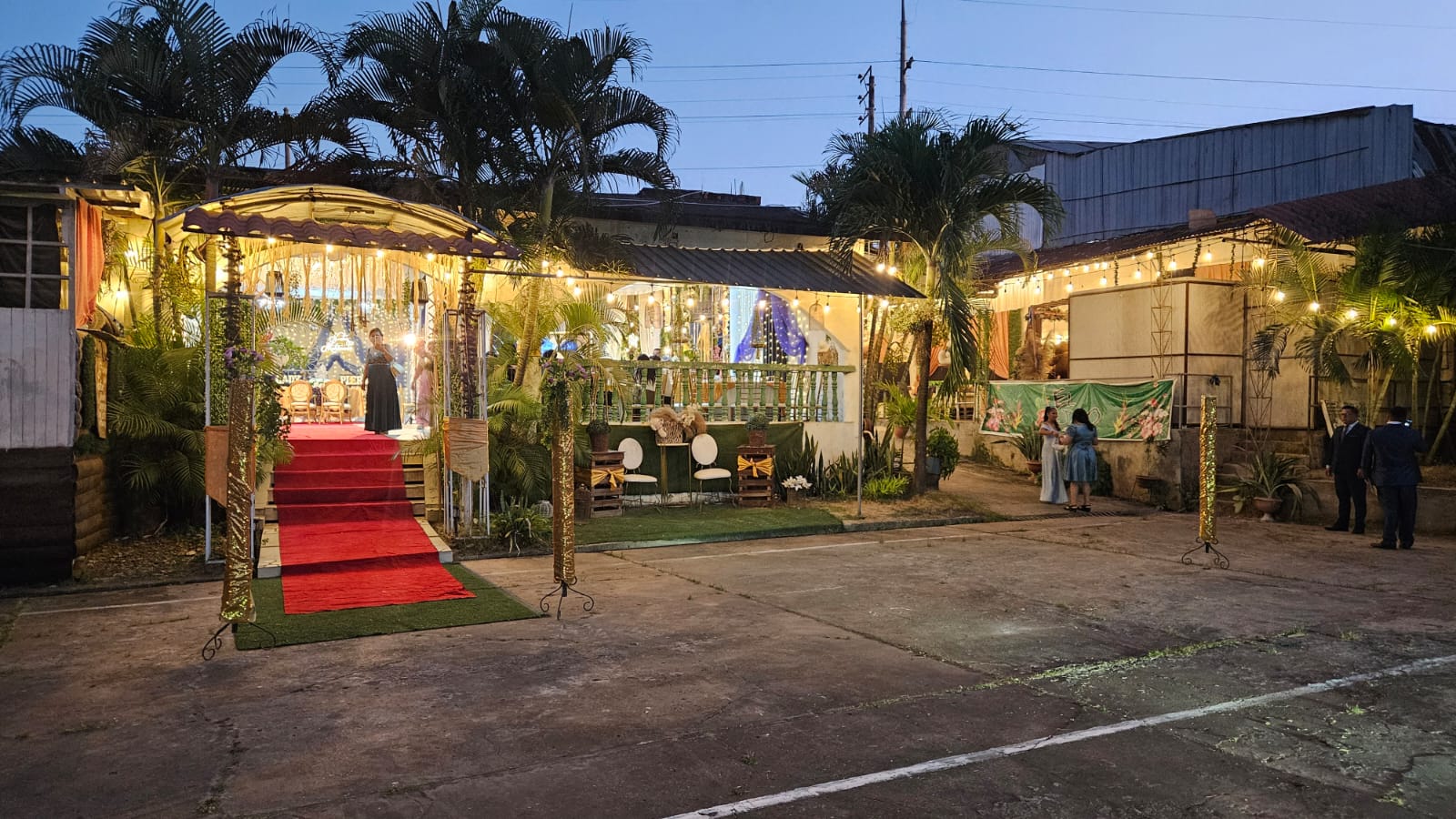 Fachada de El Bijao al atardecer con alfombra roja, palmeras y luces colgantes